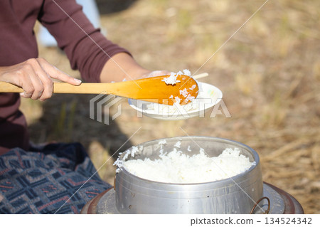 A woman serving freshly cooked rice A woman serving freshly cooked rice 134524342