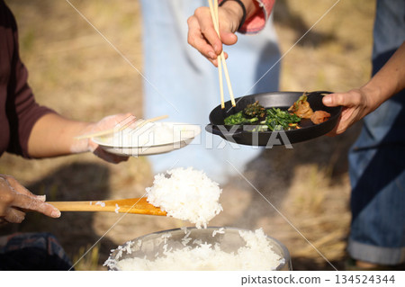 A woman serving freshly cooked rice A woman serving freshly cooked rice 134524344