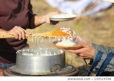 一位女士端著剛煮好的米飯 134524346