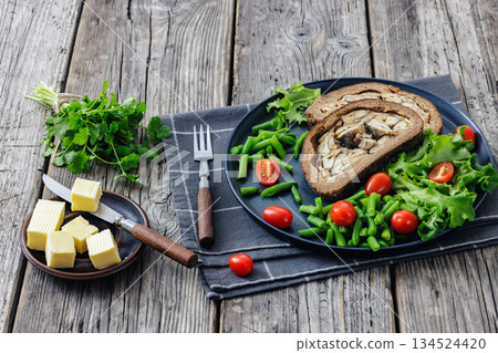 Finnish Kalakukko, fish pie on plate with veggies Finnish Kalakukko, fish pie on plate with veggies 134524420