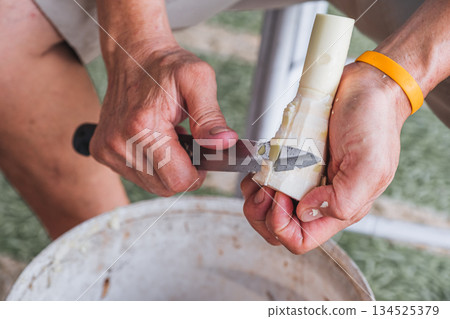 Farmer peeling bamboo shoot with knife in local market Farmer peeling bamboo shoot with knife in local market 134525379