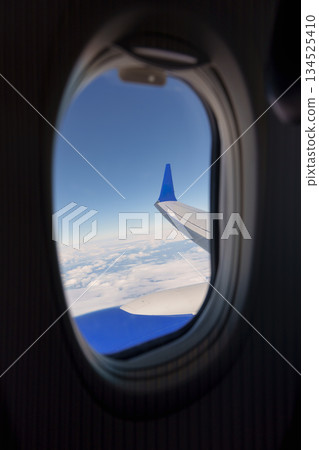 Airplane wing and clouds view from passenser window 134525410