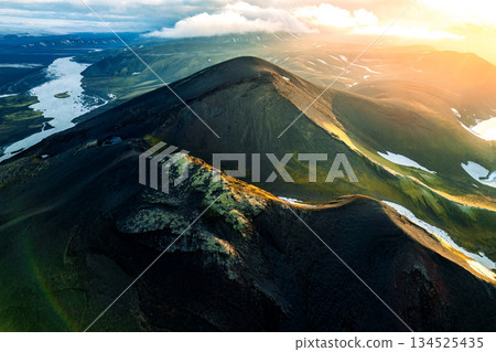 Scenic sunset over volcanic terrain and river on wilderness during summer in Iceland Scenic sunset over volcanic terrain and river on wilderness during summer in Iceland 134525435