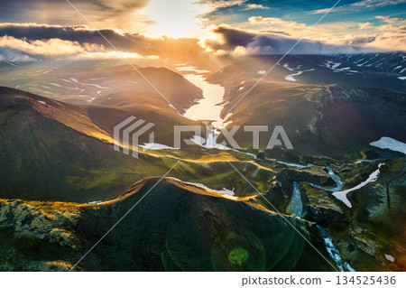 Scenic sunset over volcanic terrain and river on wilderness during summer in Iceland Scenic sunset over volcanic terrain and river on wilderness during summer in Iceland 134525436