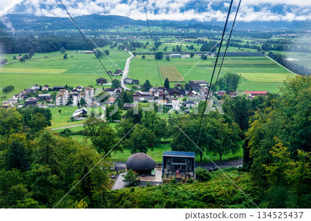 Cable car ascend overlooking lush swiss alps countryside and village houses in Appenzell Cable car ascend overlooking lush swiss alps countryside and village houses in Appenzell 134525437