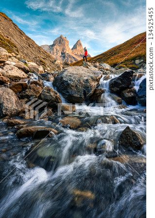 Scenic view of Aiguilles d Arves with iconic mountain peak and stream rapids flowing in French Alps 134525455
