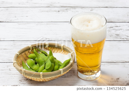 Beer and edamame beans on a white table Beer and edamame beans on a white table 134525625