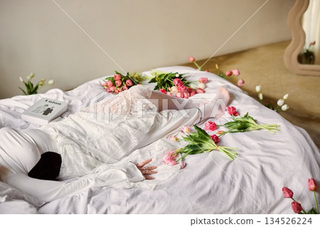 Woman relaxes peacefully, Tranquil scene depicting woman resting amidst tulips and delicate lace attire Woman relaxes peacefully, Tranquil scene depicting woman resting amidst tulips and delicate lace attire 134526224