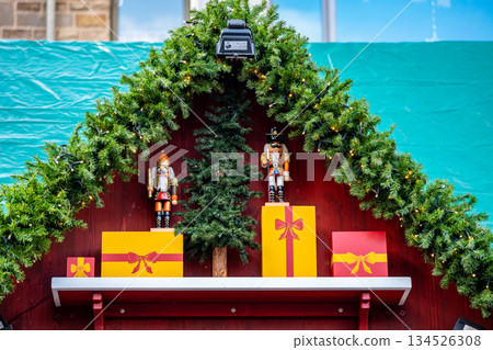 Festive Christmas market display with nutcracker dolls and wrapped gifts Festive Christmas market display with nutcracker dolls and wrapped gifts 134526308