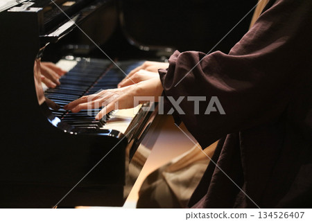 A woman playing the piano 134526407