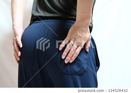 A woman complaining of low back pain A woman complaining of low back pain 134526432