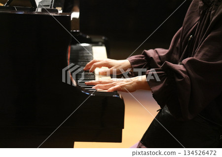 A woman playing the piano 134526472