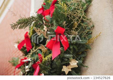A christmas wreath with branches red velvet bows and golden ivy 134527626