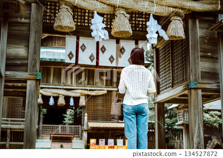 Back view of a woman heading towards the shrine's worship hall 134527872