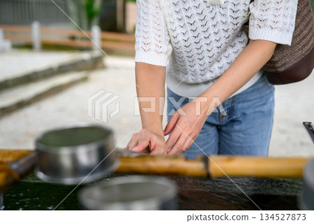 一位婦女在淨手池（洗手台）用湯匙洗手。 134527873