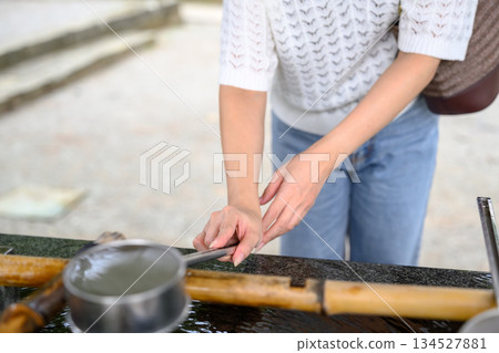一位女子在淨身池（淨身池）前手持長柄勺 134527881