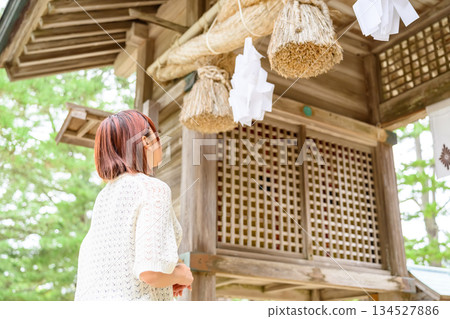 一位女子抬頭望著神社裡的注連繩。 134527886