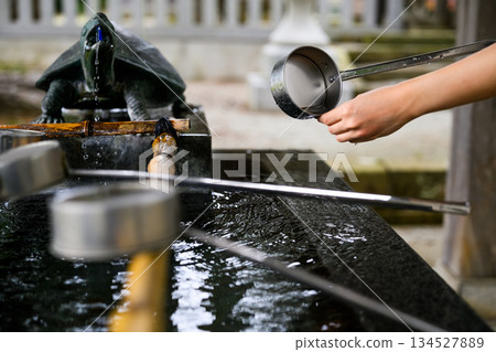 一位婦女在祈禱前用湯匙舀水。 134527889