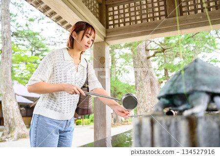 一位年輕女子在淨身池（淨身池）使用湯匙 134527916