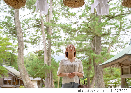 一位女子抬頭望著神社裡的注連繩。 134527921