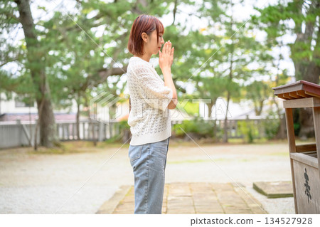 Profile of a woman praying at a shrine 134527928
