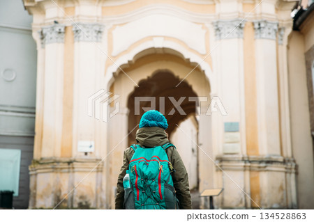 Vilnius, Lithuania. Young Beautiful Pretty Caucasian Girl Woman Tourist Smiling On Background Holy Trinity Church And Basilian Gate Vilnius, Lithuania. Young Beautiful Pretty Caucasian Girl Woman Tourist Smiling On Background Holy Trinity Church And Basilian Gate 134528863