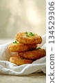 Stack of golden potato pancakes garnished with fresh dill on a soft linen napkin 134529306