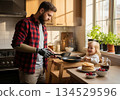 Father with prosthetic hand cook pancake at home 134529596