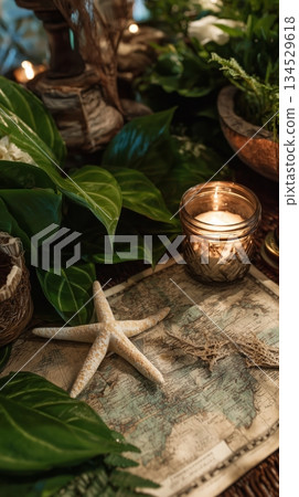 Exploring a Coastal Map With Natural Elements and a Lit Candle on a Wooden Table 134529618