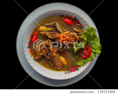 Sop Kambing Beberuk or Sapi traditional Indonesian goat rib soup specialty of Lombok isolated on black background. Sop Kambing Beberuk or Sapi traditional Indonesian goat rib soup specialty of Lombok isolated on black background. 134531006