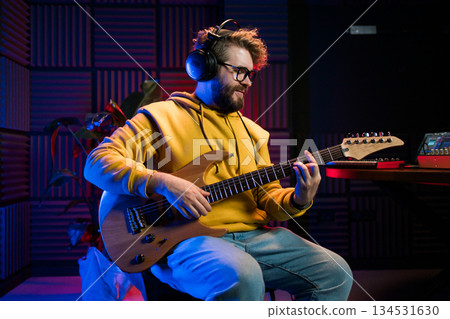 Male singer playing guitar and singing a song. Man performing in a recording studio. Recording music album. Male singer playing guitar and singing a song. Man performing in a recording studio. Recording music album. 134531630