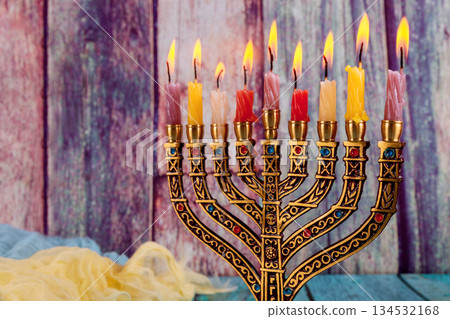 Beautiful menorah holding diverse colored candles lit for Jewish holiday festive atmosphere Hanukkah 134532168
