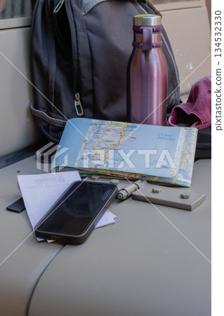 Road trip planning with backpack, map, phone, and water bottle 134532330