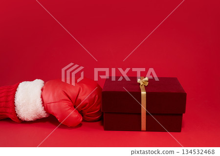 Boxing day. Christmas boxing glove next to a gift box on red background. 134532468