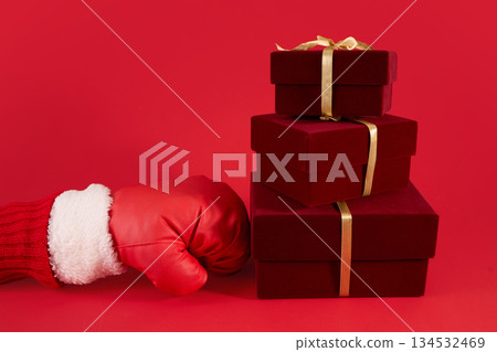 Festive Gift. Boxing day. Red boxing glove beside stacked red gift boxes 134532469