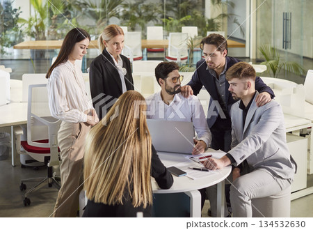 Colleagues Collaborating On Laptop And Documents In Office Meeting 134532630
