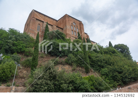 Historic stone building on a green hill under cloudy sky. European architecture and travel concept. Italy Historic stone building on a green hill under cloudy sky. European architecture and travel concept. Italy 134532692