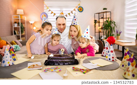 Family celebration with children around a birthday cake and candles Family celebration with children around a birthday cake and candles 134532783