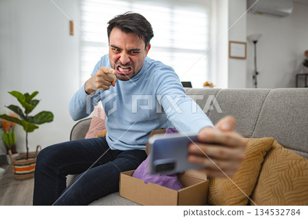 Angry men talking on a video call while unboxing a gift Angry men talking on a video call while unboxing a gift 134532784