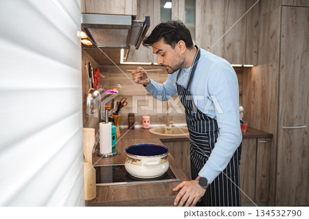 Man Standing in Kitchen Preparing Food Man Standing in Kitchen Preparing Food 134532790