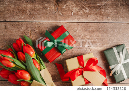 Mothers' day. Red tulips with gift boxes. Easter holiday. Wooden background, copy space. Mothers' day. Red tulips with gift boxes. Easter holiday. Wooden background, copy space. 134532828