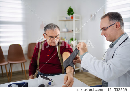 Caring doctor checks blood pressure of senior patient in clinic Caring doctor checks blood pressure of senior patient in clinic 134532839