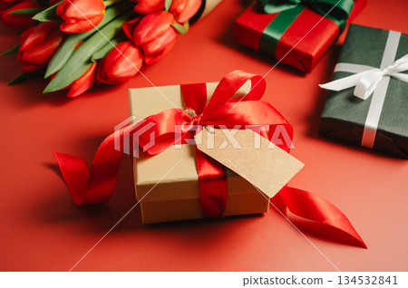 Mothers' day. Gift boxes and fresh red spring tulips. Easter holiday. Red background Mothers' day. Gift boxes and fresh red spring tulips. Easter holiday. Red background 134532841