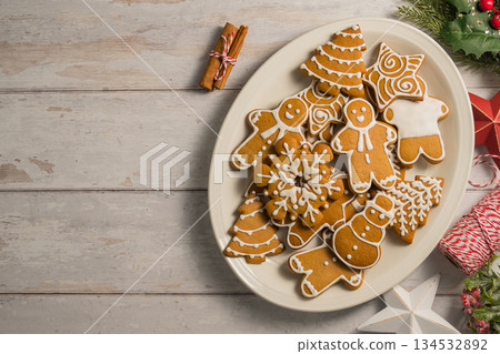 Holiday background. Christmas gingerbread cookies in different shapes in a plate, copy space 134532892