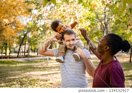 Family enjoying a playful autumn day in the park with laughter Family enjoying a playful autumn day in the park with laughter 134532917