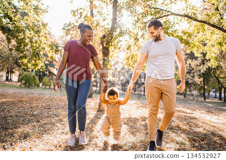 Joyful swing between parents in the park Joyful swing between parents in the park 134532927