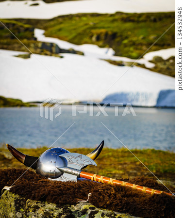 Viking helmet on lake shore, Norway 134532948
