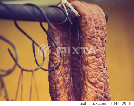 Smoked sausages meat hanging in smokehouse Smoked sausages meat hanging in smokehouse 134532966
