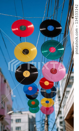 Colorful vinyl records hanging outdoors on a wire display urban artistic installation 134533142