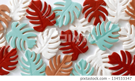 Colorful tropical leaf cookies with icing accents on white background 134533347